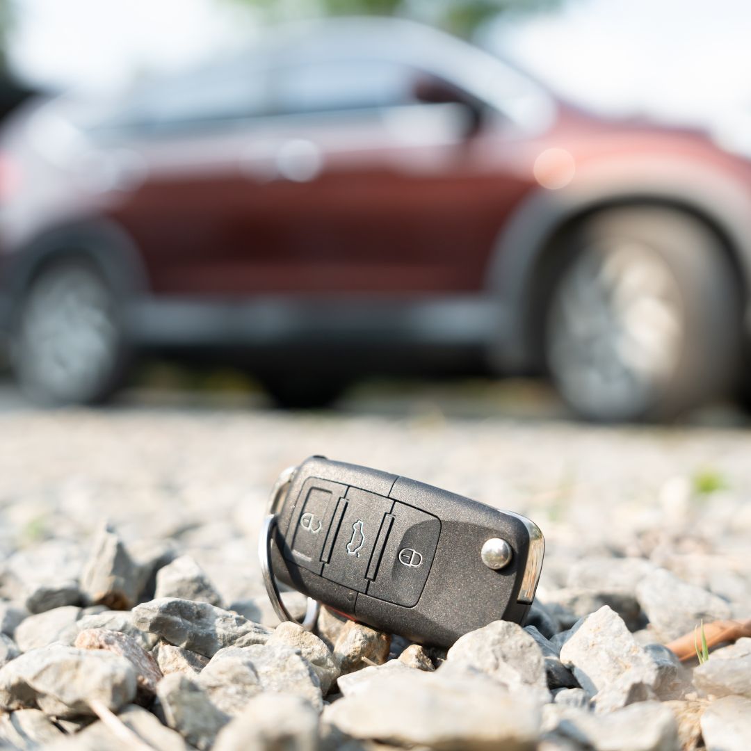 car keys stolen, a remote car key on the ground beside a car